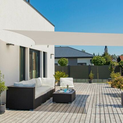 Terrasse eines modernen Hauses mit Loungesofa, Gartentisch und Sonnensegel